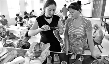  ?? LIU JUNXI / XINHUA ?? Wu Luanying, a resident from Wangji village, Sixian county, Anhui province, learns how to make traditiona­l cloth shoes at a local poverty alleviatio­n workshop. People like her can earn $12 per day through this program.