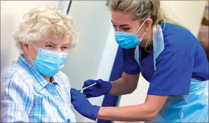  ??  ?? FIRST DOSE: A woman at a vaccinatio­n centre in Haxby near York getting her jab from nurse practition­er Terri Welch