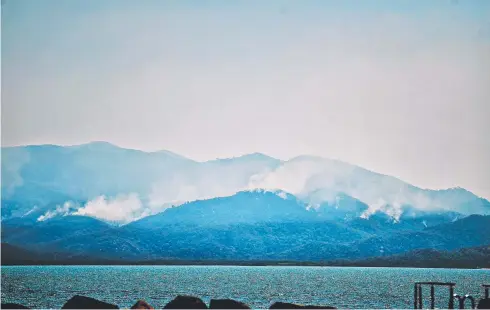  ??  ?? BURNING ISSUE: Smoke billows from Magnetic Island from controlled backburnin­g.