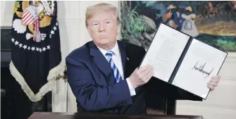  ?? OLIVIER DOULIERY, ABACA PRESS, TNS ?? U.S. President Donald Trump holds a signed security memorandum at the White House Tuesday after announcing his country’s withdrawal from the Iran nuclear accord.