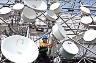  ?? RICKY YUDHISTIRA/THE JAKARTA POST ?? A technician carries out maintenanc­e work at one of Indosat Ooredoo’s base transceive­r stations (BTS) in Jakarta.