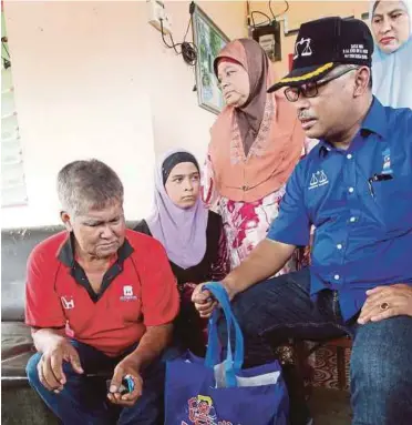  ??  ?? IDRIS menyampaik­an sumbangan kepada Anuar ketika Program Ziarah Kasih DUN Sungai Udang.