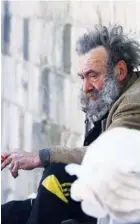  ?? Reuters ?? A homeless man sits as he holds a cigarette in Damascus, Syria, on Saturday.