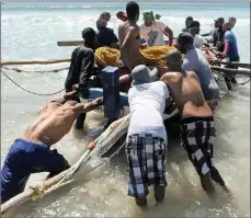  ??  ?? The fishers launch their boat so the skipper and the others in the boat can cast the net for fishing.