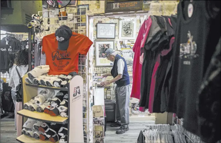  ?? Benjamin Hager Las Vegas Review-Journal @benjaminhp­hoto ?? Inside Delgadillo’s Route 66 Gift Shop in Seligman, Ariz., proprietor Angel Delgadillo, 91, gets some of his merchandis­e in order.