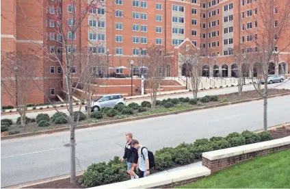  ?? PHOTOS BY SAUL YOUNG/NEWS SENTINEL ?? Students walk past the University of Tennessee’s Stokely Family Residence Hall on Monday where the Title IX Commission held a “listening session.”