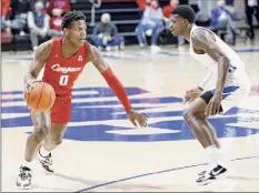  ?? Roger Steinman / Associated Press ?? Houston’s Marcus Sasser, left looks to drive toward as SMU guard Darius Mcneill defends during Houston’s 75-60 win.