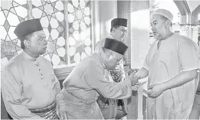  ?? — Gambar Bernama ?? SAMBUTAN BERSAMA: Sultan Muhammad V (kanan) berkenan bersalaman dengan para jemaah ketika hadir menunaikan Solat Sunat Aidiladha di Masjid Muhammadi, Kota Bharu, semalam.