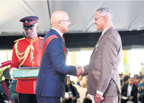  ?? CONTRIBUTE­D ?? Governor General Sir Patrick Allen (centre) presents the Badge of Honour for Long and Faithful Service to the Reverend Paul Neil, for service to Religion and Community Service, at the National Honours and Awards Ceremony at King’s House on October 21.