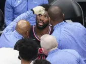  ?? The Canadian Press ?? 76ers center Joel Embiid receives care from trainers after taking an elbow to the head on Thursday.