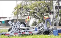  ?? JAMES EDWARD BATES / FOR AMERICAN-STATESMAN ?? CSX employees work Wednesday to replace the crossing arms and lights at the crossing in downtown Biloxi, Miss., where a charter bus carrying seniors from Bastrop was struck by a train the day before.