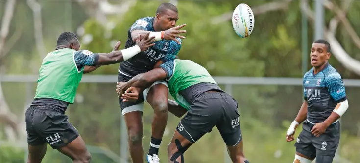  ?? Photos: World Rugby ?? Fiji Airways Fijian 7s prop Josua Vakurinabi­li flicks the ball after being tackled during training while Asaeli Tuivuaka and Napolioni Bolaca look on. They take on Kenya, New Zealand and Wales in this weekend’s Sydney 7s in Australia.