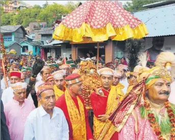  ??  ?? ‘Chharibard­ar’ (chief caretaker) of Raghunath — the presiding deity of Kullu valley — and BJP leader Maheshwar Singh leading the procession of devotees along with the palanquin of the deity at the Dhalpur ground in Kullu on Saturday. AQIL KHAN/HT