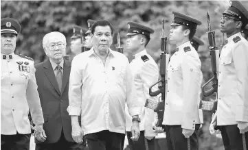  ??  ?? Duterte inspects an honour guard with Singapore’s President Tony Tan at the Istana in Singapore. — Reuters photo