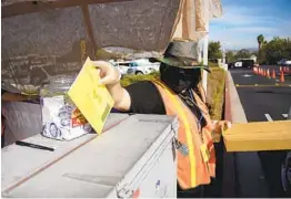  ?? ALEJANDRO TAMAYO U-T ?? A poll worker drops a ballot in the box on Election Day. More than a quarter of county precincts reported turnout below 80 percent.