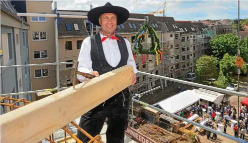  ?? FOTOS: LUTZ EBHARDT ?? Dachdecker­meister Yves Plock sprach in luftiger Höhe den Richtspruc­h für den Neubau in der Augustiner­straße 13.