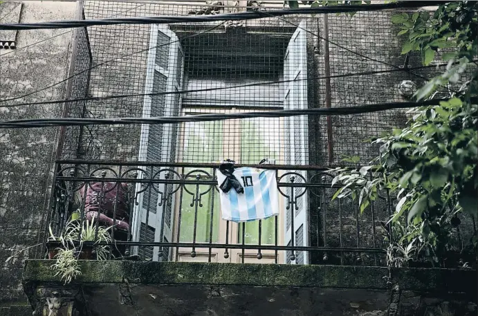  ?? TOMAS CUESTA / GETTY ?? EL ADIÓS DE UN ARGENTINO UNIVERSAL
Una camiseta de la selección argentina con el dorsal 10 de Maradona luce enlutada en el balcón de una vivienda del barrio de La Boca, en Buenos Aires