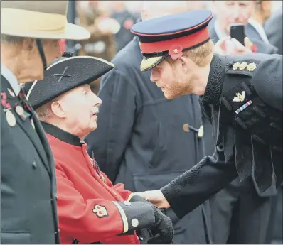  ?? PICTURE: JEREMY SELWYN/EVENING STANDARD/PA WIRE. ?? ROYAL TRIBUTE: Prince Harry meets veterans at Westminste­r Abbey’s Field of Remembranc­e.