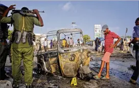  ?? FARAH ABDIWARSAM­EH / AP ?? Somali soldiers and a boy stand near the wreckage of a three-wheeledmot­orcycle taxi at the scene of a car bomb explosion near the parliament building in the capital Mogadishu, Somalia, on Sunday. A car bomb exploded near Somalia’s parliament...