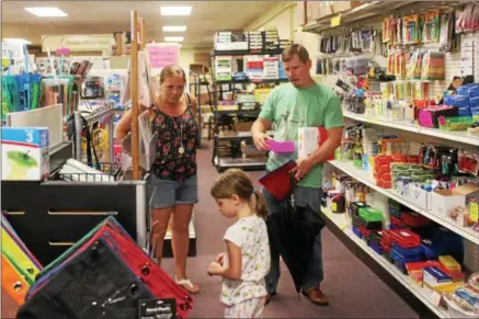  ?? CHARLES PRITCHARD — ONEIDA DAILY DISPATCH ?? Alison Baker, left, talks with a father and daughter as they shop for school supplies on Tuesday, Aug. 14, 2018.