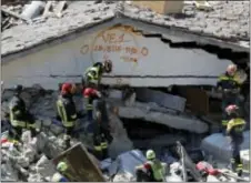  ?? GREGORIO BORGIA — THE ASSOCIATED PRESS ?? Rescuers mark a building with paint signaling the date and time of start and end of the search operation on that building, following Wednesday’s earthquake in Pescara Del Tronto, Italy, Thursday. Rescue crews raced against time Thursday looking for...