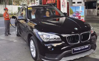  ??  ?? Robinsons Rewards’ Christmas promo raffle draw winner Rose Ong (driver’s seat) getting a Caltex with Techron full tank bonus with Chevron Philippine­s Inc. country chair Peter Morris