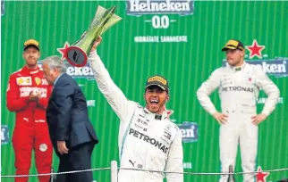  ??  ?? Arriba! Lewis Hamilton clutches his Heineken trophy as he celebrates winning the Mexican GP.