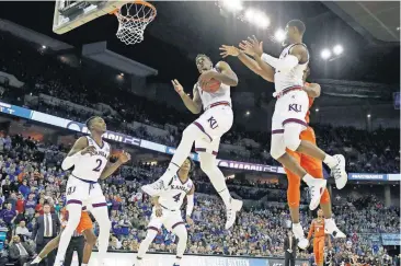  ?? [CHARLIE NEIBERGALL/THE ASSOCIATED PRESS] ?? Kansas’ Silvio De Sousa pulls down a rebound during the first half of a regional semifinal against Clemson Friday in Omaha, Neb.