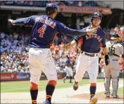  ?? DAVID J. PHILLIP / AP ?? The Astros’ George Springer welcomes home Josh Reddick after they both scored on a single by Brian McCann in the fifth inning Sunday.