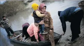  ?? MANU BRABO/ THE ASSOCIATED PRESS ?? Syrian refugees escape from Syria to Turkey by crossing the Orontes River, near the village of Hacipasa in Turkey on Saturday.