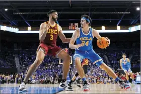  ?? MARK J. TERRILL — THE ASSOCIATED PRESS FILE ?? UCLA guard Jaime Jaquez Jr., right, tries to get by Southern California forward Isaiah Mobley during the second half of an NCAA college basketball game on March 5, 2022, in Los Angeles. UCLA and Southern California are planning to leave the Pac-12for the Big Ten Conference in a seismic change that could lead to another major realignmen­t of college sports. A person who spoke to The Associated Press on Thursday, June 30, 2022, on condition of anonymity because the schools’ talks with the Big Ten have not been made public said the schools have taken steps to request an invitation to join the conference.