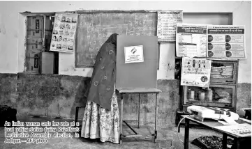  ??  ?? An Indian woman casts her vote at a local polling station during Rajasthan’s Legislativ­e Assembly election, in Jodhpur. — AFP photo