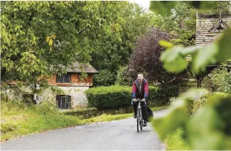  ??  ?? TOP Thatched roundhouse­s at the archaeolog­ical open-air museum Butser Ancient Farm, which recreates our early ways of life ABOVE Dixe pedals through the peaceful village of Bignor on his way to the Roman villa