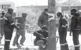  ??  ?? Bulawayo City Council Electrical Engineerin­g Department workers fix street lights at the Zupco pick up point along 8th Avenue Extension and Lobengula Street in Bulawayo yesterday. Commuters complained of poor lighting and potential exposure to robberies at the commuter omnibus pick up point after sunset. — (Picture by Nkosizile Ndlovu)