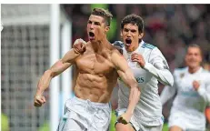  ?? FOTO: BLONDEAU/DPA ?? Cristiano Ronaldo (links) zeigt der Welt seinen Oberkörper nach dem entscheide­nden Tor gegen Turin. Jesus Vallejo findet’s super.