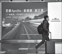  ?? CHEN YIHANG / FOR CHINA DAILY ?? A passenger passes a Baidu Apollo poster at Baiyun Internatio­nal Airport in Guangzhou, Guangdong province, on Jan 3.