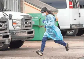  ?? JAY JANNER/USA TODAY NETWORK ?? Pharmacist Emily Chu runs back to her post at a drive-thru COVID-19 vaccine clinic in South Austin, Texas, on Wednesday.