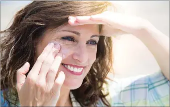  ??  ?? Woman applying moisturise­r to her face.