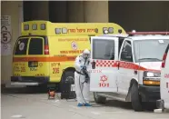  ?? (Gili Yaari /Flash90) ?? A MEDICAL team cleans and disinfects an ambulance at Tel Aviv’s Dan Panorama hotel yesterday.