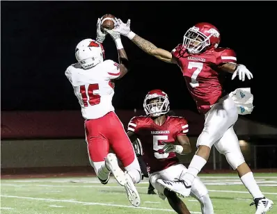  ?? Staff photo by Hunt Mercier ?? ■ Camden Cardinals wide receiver Jalen Moore catches the ball and runs in for a touchdown while being guarded by Razorback defensive backs Dejordan Mask (5) and Jaylon Bead on Friday at Arkansas High School in Texarkana, Ark.