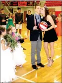  ??  ?? Farmington’s 2017 Colors Day queen, Claudia Oxford, daughter of Jeff and Ree Oxford, presents the king’s trophy to Javan Jowers, 2018 Farmington Colors Day King, then adds a kiss as the attendants look on.