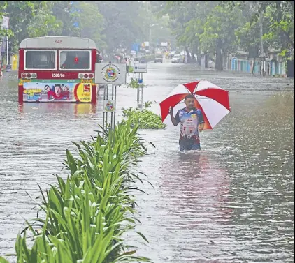  ?? REUTERS FILE ?? A man wades through a waterlogge­d road in Mumbai. In August, the city received about 30% of its annual rain in less than 24 hours.