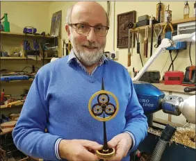  ??  ?? Fr Jim Cogley, with one of his famed creations representi­ng the holy trinity.