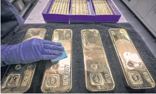  ?? AFP ?? A worker polishes gold bars at the ABC Refinery in Sydney.