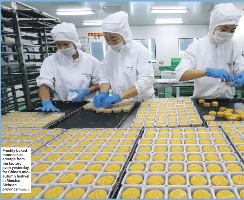  ??  ?? Freshly baked mooncakes emerge from the factory oven yesterday for China’s midautumn festival in Meishan, Sichuan province