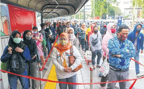  ??  ?? Passengers queue at the Tanah Abang railway station in Jakarta, which returned to large-scale social restrictio­ns last week.