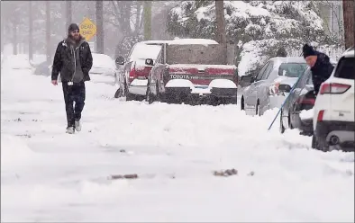  ??  ?? A man walks down Ohio Street following the snowstorm.