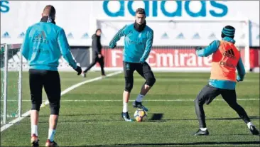  ??  ?? NECESITADO­S. Benzema (de espaldas) y Cristiano, en un momento del entrenamie­nto de ayer.