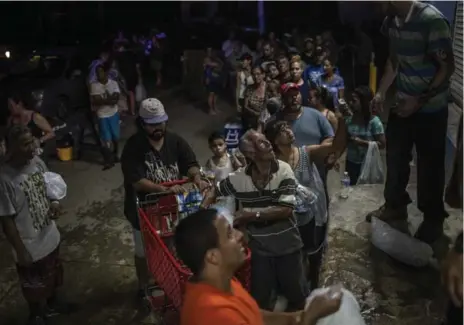  ?? KIRSTEN LUCE/THE NEW YORK TIMES ?? People wait in line to buy ice in Arecibo, Puerto Rico. More than a week after hurricane Maria hit, many remain desperate for food, water and fuel.