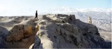  ?? Agence France-presse ?? ↑
A Hazara man walks on a hilltop at the Shahr-e Gholghola archaeolog­ical site overlookin­g Bamiyan on Thursday.